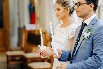 European couple's wedding ceremony. Newlyweds hold candles in their hands