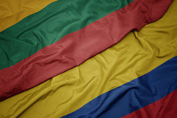 waving colorful flag of colombia and national flag of lithuania.