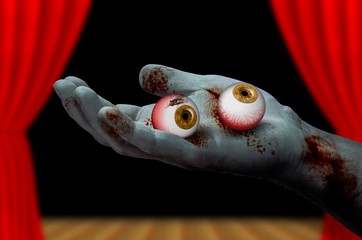 Zombie hand holding a pair of eyeballs