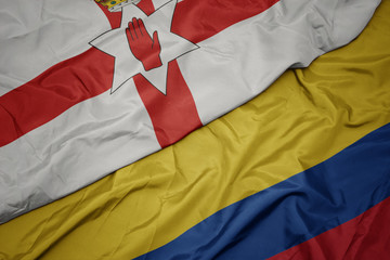 waving colorful flag of colombia and national flag of northern ireland.