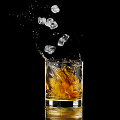 Ice flow in a whiskey glass and splash