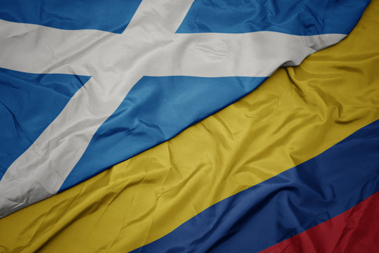 waving colorful flag of colombia and national flag of scotland.