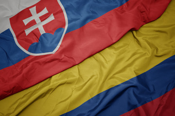 waving colorful flag of colombia and national flag of slovakia.