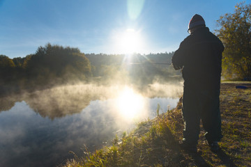 man catches fish on the river Snov in autumn, October 2018. Ukraine, the city of Chernigov