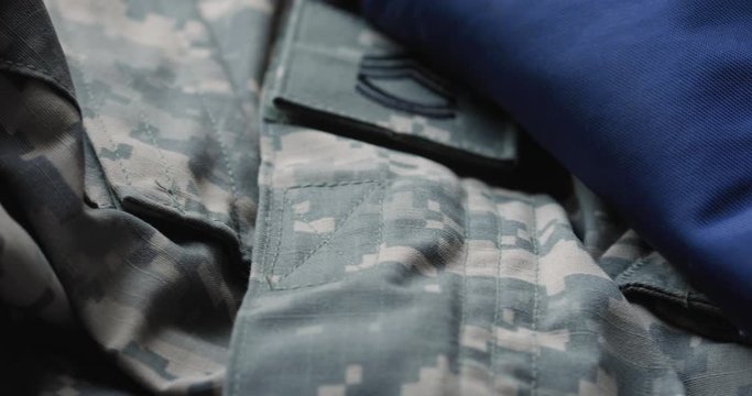 Video Slider Across Folded United States Flag And Army Camoflauge Uniform