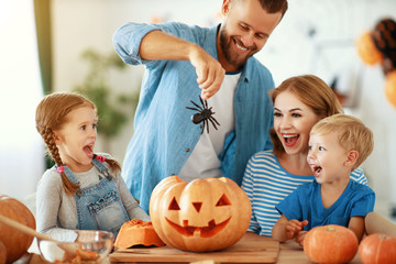 Fototapeta premium happy Halloween! family mother father and children cut pumpkin for holiday at home..