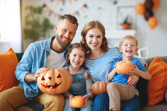 happy  family mother father and children prepare for Halloween decorate  home with pumpkins,  laughing and  play