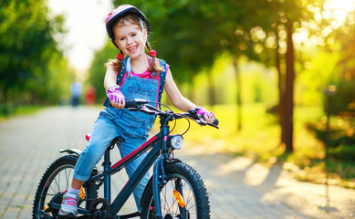 happy cheerful child girl riding a bike in Park in nature