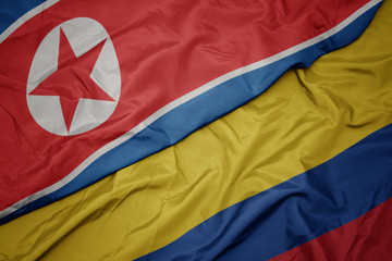 waving colorful flag of colombia and national flag of north korea.