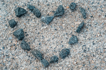 A heart made of gravel on a stone surface