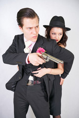 man in classic costume with gun protect his girlfriend on white studio background