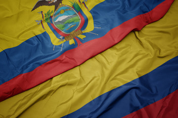 waving colorful flag of colombia and national flag of ecuador.