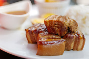 Close up view of Kakuni, Japanese Braised Pork Belly, with rice and soup on white plate. 