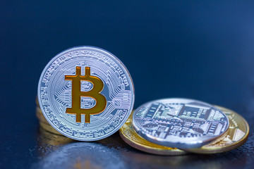 silberne und goldene Bitcoin Münzen vor dunklem Hintergrund (virtuelles Geld oder Kryptowährung)