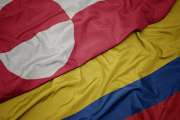 waving colorful flag of colombia and national flag of greenland.
