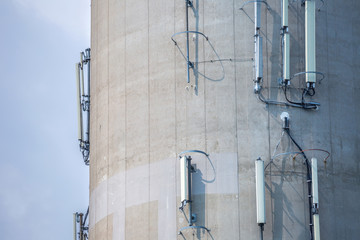 Telecommunication equipment (receivers and transmitters) of mobile network and Internet located on a reinforced concrete wall of a large industrial facility.