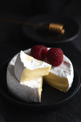 coffe, camembert, raspberries, honey on a dark backgraund minimalistic, breakfast