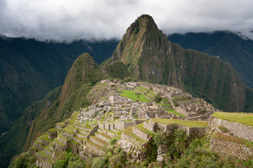 Machu Picchu ruins with cloudy sky in the back