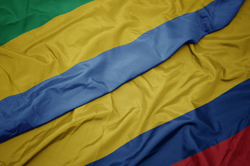 waving colorful flag of colombia and national flag of gabon.