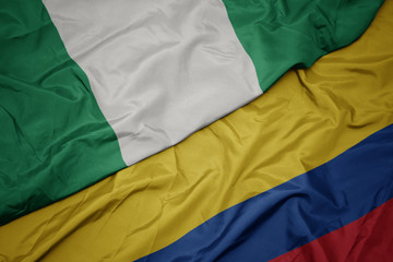 waving colorful flag of colombia and national flag of nigeria.