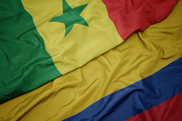 waving colorful flag of colombia and national flag of senegal.