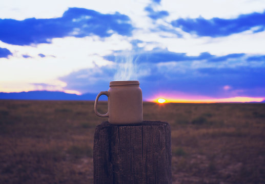Steaming Cup of Morning Coffee In Western Ranch Scene At Sunrise