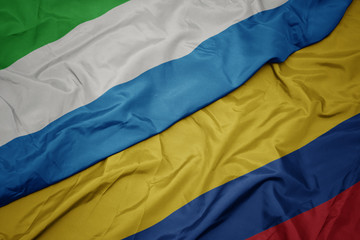 waving colorful flag of colombia and national flag of sierra leone.