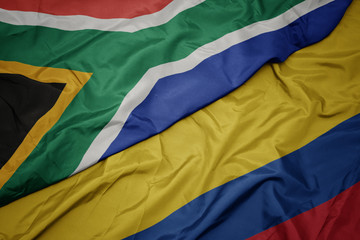 waving colorful flag of colombia and national flag of south africa.