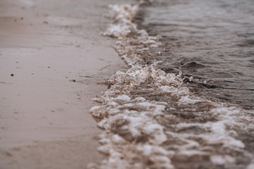 The tide of water on the beach. Water and sand. Beach vacation.