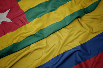 waving colorful flag of colombia and national flag of togo.