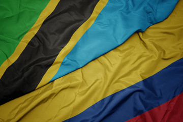 waving colorful flag of colombia and national flag of tanzania.