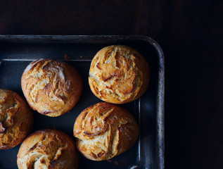 Hot homemade burger buns on a baking sheet top view