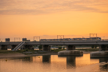 Dutch train crossing bridge at sunset