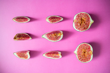 Flat lay with slices figs on a pink background.
