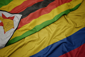 waving colorful flag of colombia and national flag of zimbabwe.