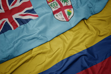 waving colorful flag of colombia and national flag of Fiji .