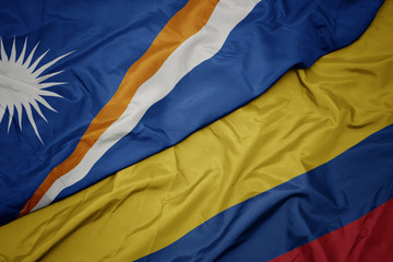 waving colorful flag of colombia and national flag of Marshall Islands .
