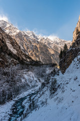 Fototapeta na wymiar Snow covered Himalayan mountains and pine forest with a river running through the valley
