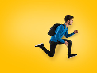 Young student fast run on yellow background