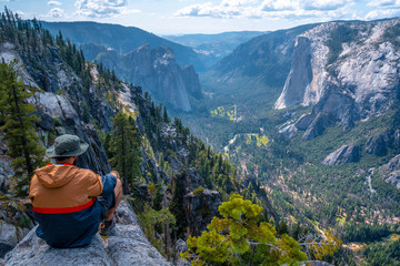 Naklejka premium A young winged seated Taft point looking at Yosemite National Park and El Capitan. United States