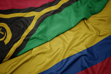 waving colorful flag of colombia and national flag of Vanuatu .