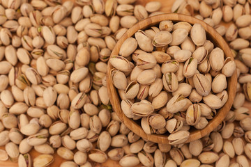 Top view of shell pistachios in wooden bowl