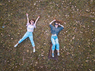 Two girl lying in the grass aerial