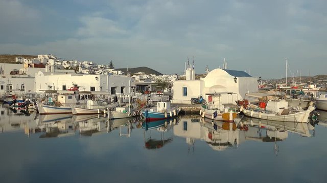 Panoramic view of Paros island popular tourist attraction, Naousa town.  Promenade zone along port with restaurants and shops. Harbor of Aegean Sea, boats and yachts in quay at calm morning. Greece