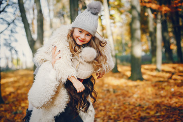 Beautiful mother with daughter. Family in a autumn park. Golden autumn