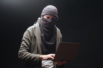 A terrorist with a laptop is preparing a crime at night