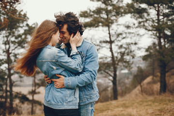 gentle and stylish couple are having a walk in the autumn park