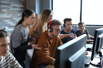 Obraz premium Group of people playing video games in internet cafe