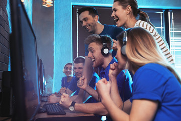 Group of people playing video games in internet cafe
