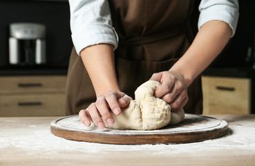 Fototapeta premium Female baker preparing bread dough at table, closeup